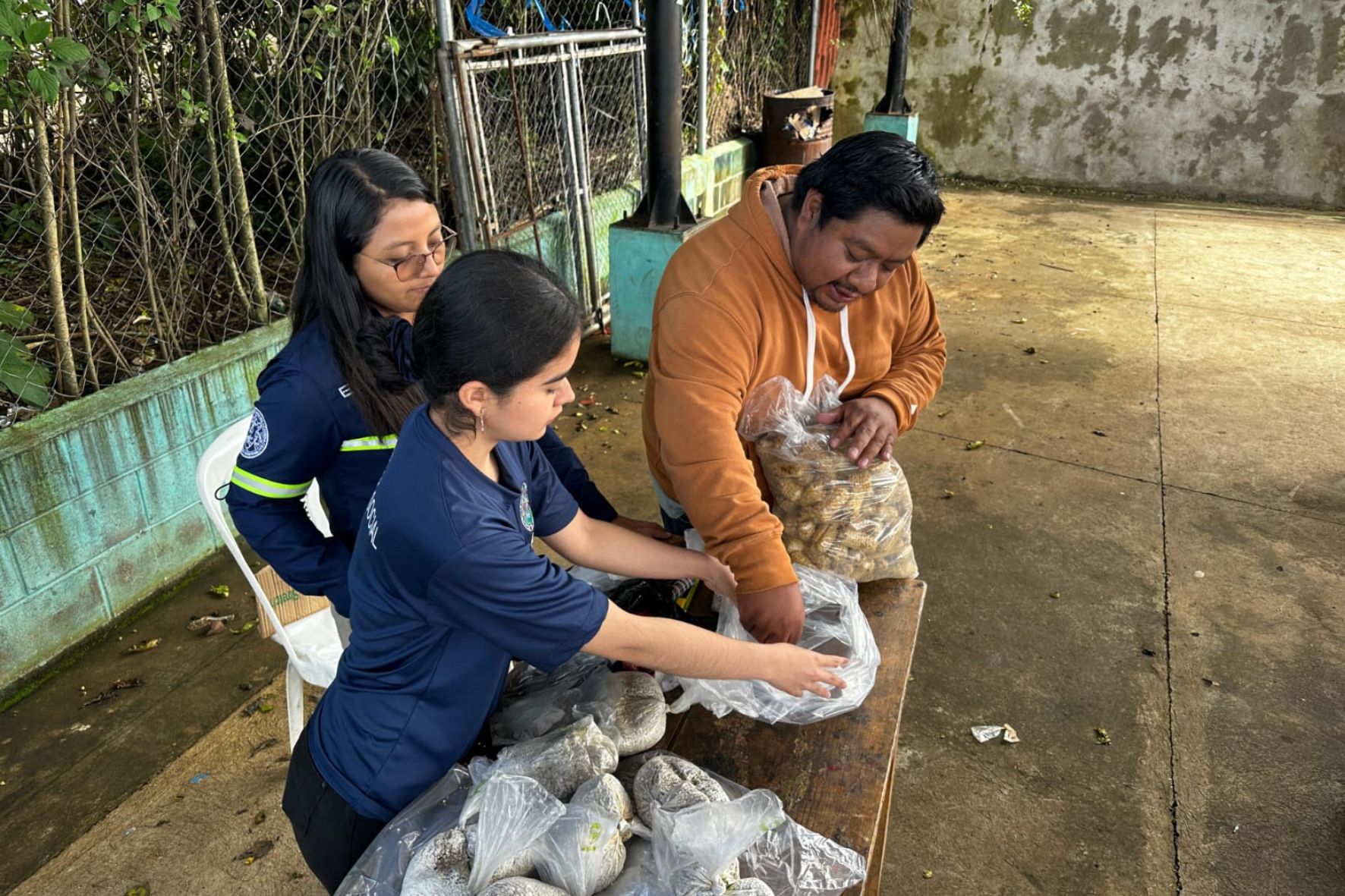 Epesistas entregando material para huertos en aldea Agua Tibia II. (Foto: EPSUM / AUN)